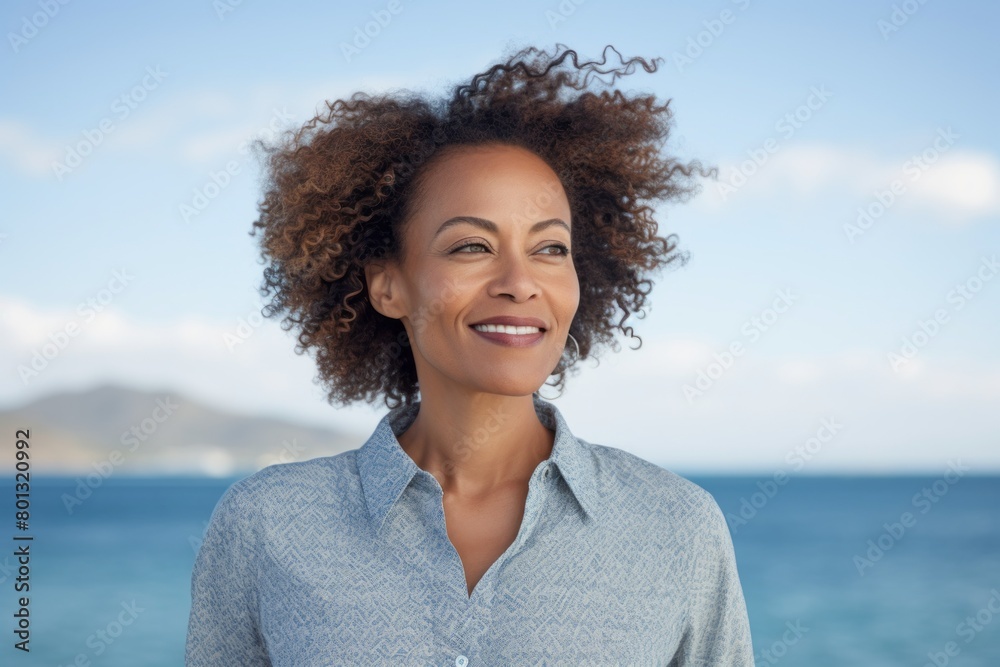 Portrait of a content afro-american woman in her 40s donning a classy polo shirt while standing against tranquil ocean backdrop Portrait of a content afro-american woman in her 40s donning a classy polo shirt while standing against tranquil ocean backdrop