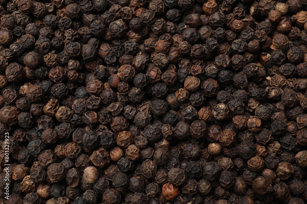Aromatic spice. Black peppercorns as background, top view