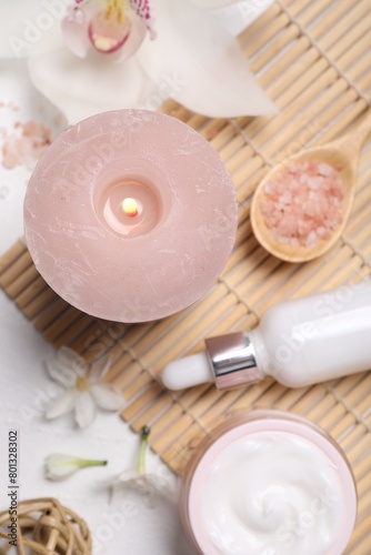 Beautiful spa composition with cosmetic products and flowers on white table, flat lay