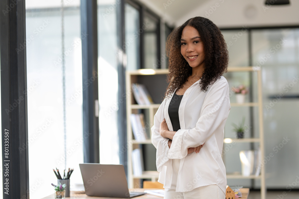 Young African American businesswoman stands confidently in a stylish office environment, portraying professionalism and success. Young African American businesswoman stands confidently in a stylish office environment, portraying professionalism and success.