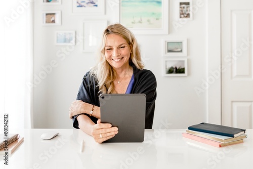 Blonde woman using tablet  video call during the new normal