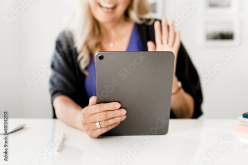 Woman waving during video call on tablet  business online meeting image