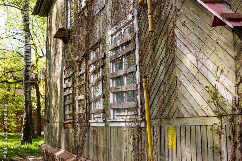 Wall of an old abandoned house with boarded up windows and turned off gas Wall of an old abandoned house with boarded up windows and turned off gas