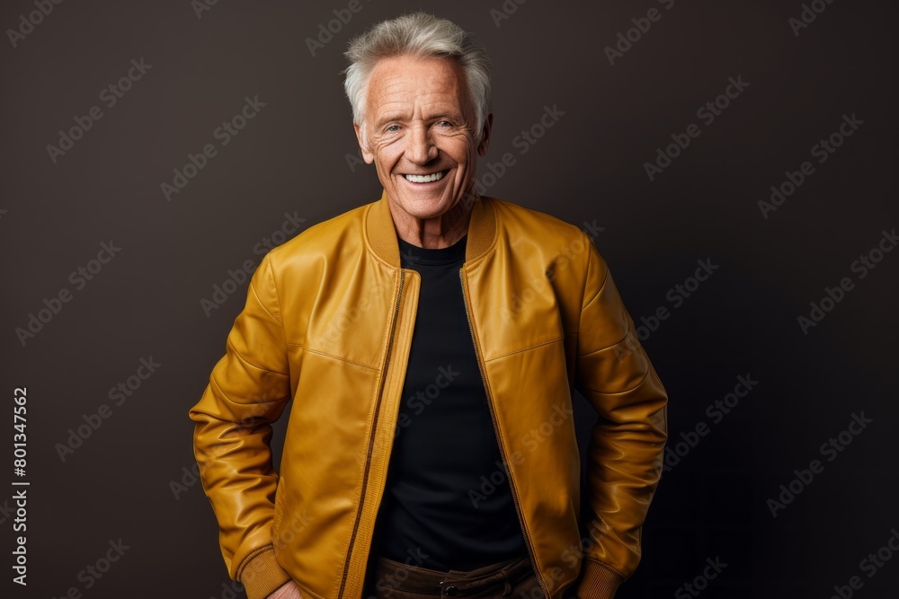 Portrait of a joyful man in his 70s sporting a stylish varsity jacket over modern minimalist interior Portrait of a joyful man in his 70s sporting a stylish varsity jacket over modern minimalist interior