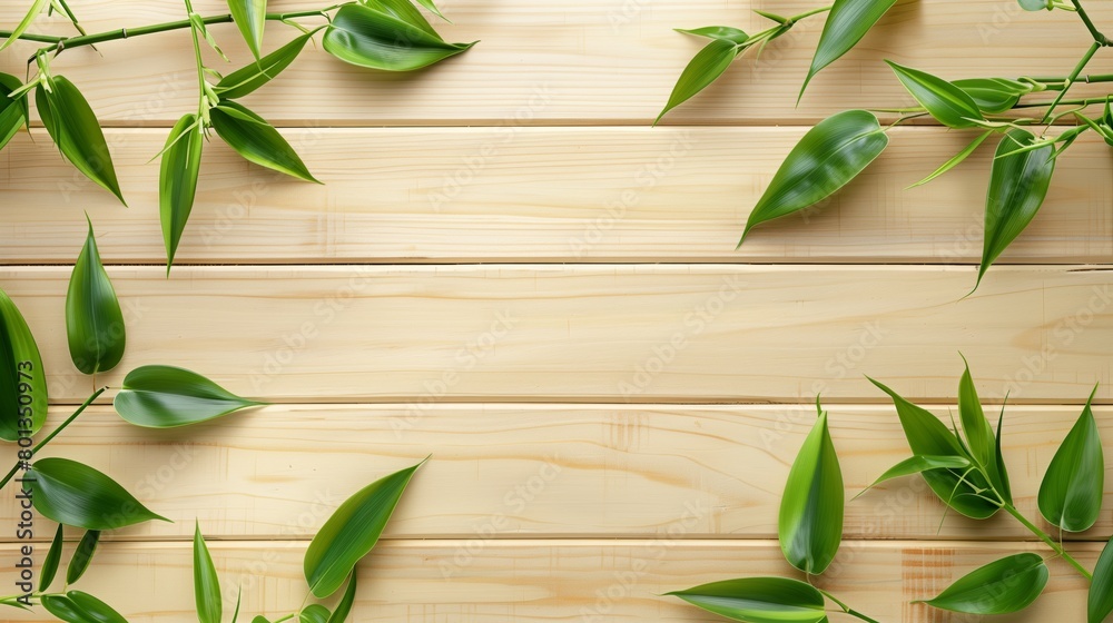 Lush green bamboo leaves organized neatly over a light wooden background with ample copy space. Lush green bamboo leaves organized neatly over a light wooden background with ample copy space.