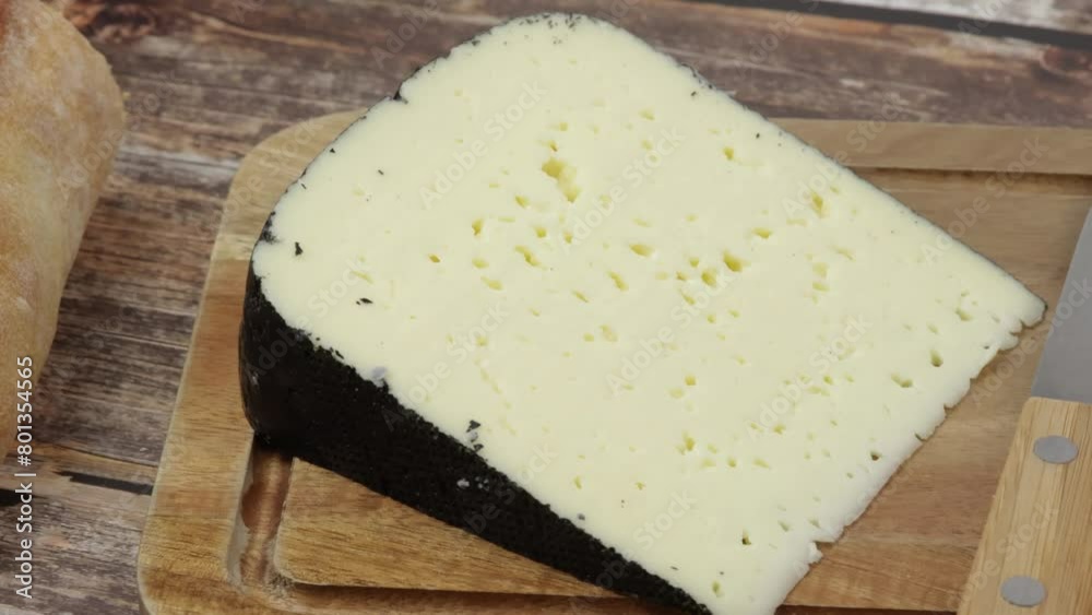 tranche de fromage : tomme noire des Pyrénées, en gros plan, sur une table tranche de fromage : tomme noire des Pyrénées, en gros plan, sur une table