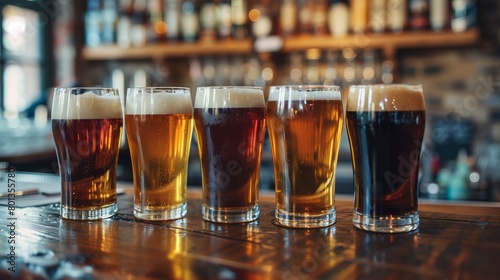 Different types of beer in glasses on a bar counter with a blurred background of a bar shelf.