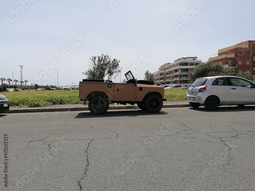 Ostia, Rome, Italy - May 2, 2024, an old Land Rover Defender convertible, 4x4 off-road vehicle, produced from 1948 to 2016, parked near the sea.