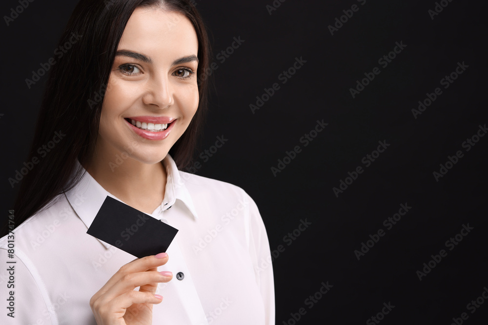 Happy woman holding blank business card on black background. Space for text Happy woman holding blank business card on black background. Space for text