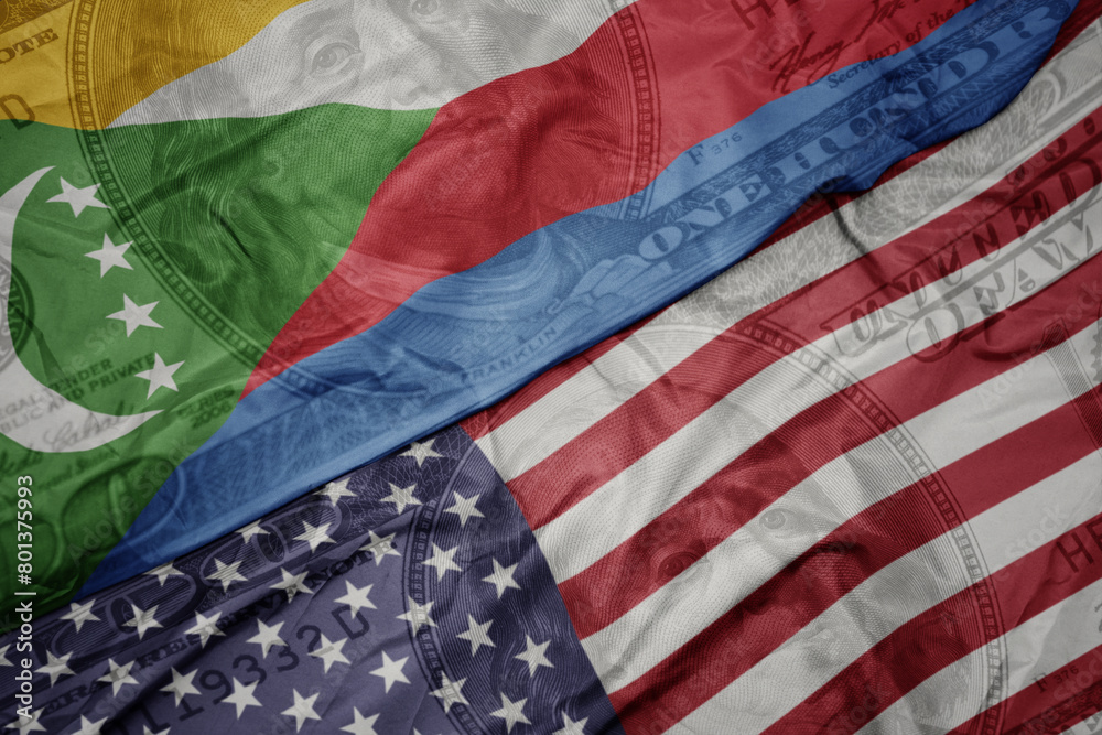 waving colorful flag of united states of america and national flag of comoros on the dollar money background. finance concept. waving colorful flag of united states of america and national flag of comoros on the dollar money background. finance concept.