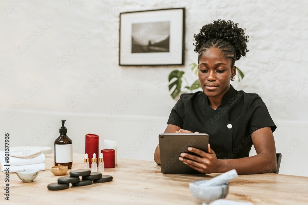 African American spa attendant using tablet for work