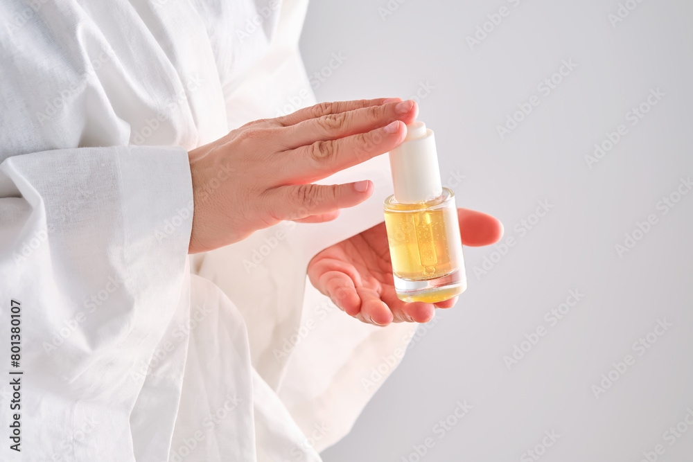 Blue serum with pipette in a womans hands in a robe. Blue serum with pipette in a womans hands in a robe.