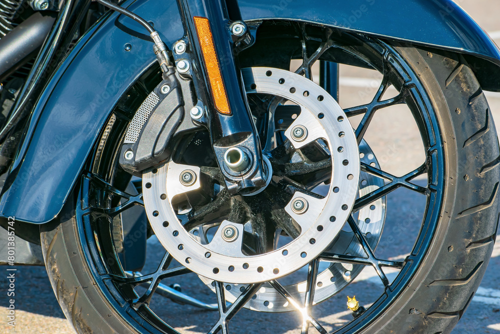 brake disc with the brake system of the front wheel of the chopper. front fork with side reflector. detailed view. brake disc with the brake system of the front wheel of the chopper. front fork with side reflector. detailed view.