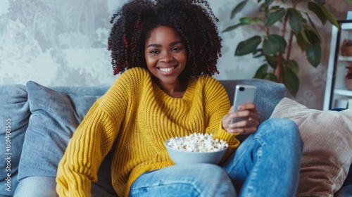 Smiling Woman with Smartphone and Popcorn photo