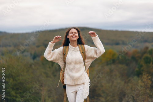 Smiling Woman on a Mountain Cliff, Enjoying an Adventure in Nature