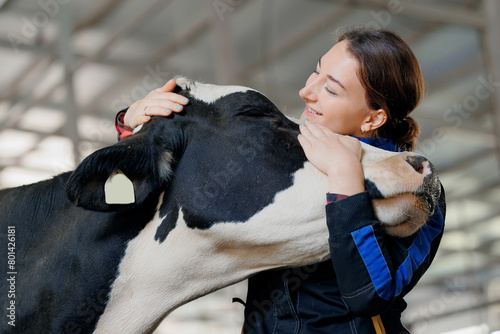 Happy young woman farm worker hugging cow as sign of concern for animal health care. Concept agriculture cattle livestock farming industry photo