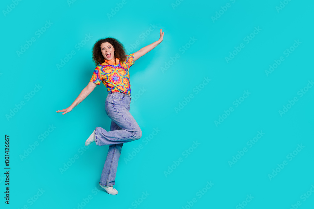 Photo of carefree lovely nice woman wear trendy print clothes dance empty space isolated on cyan color background