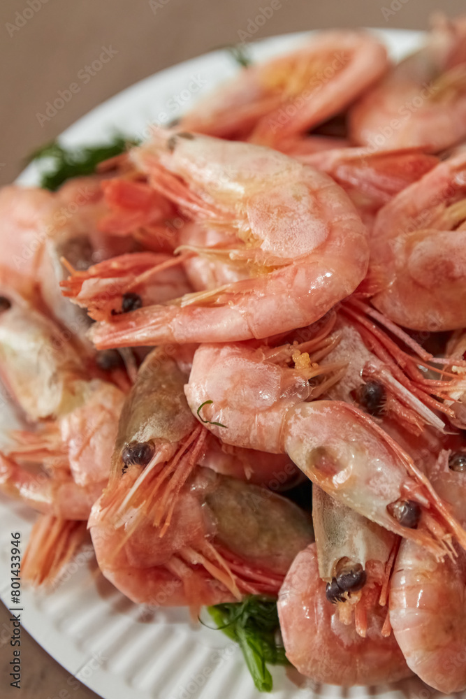 Boiled shrimps lie on a plate, seafood delicacies, shrimps on a plate, boiled shrimps, close-up, vertical shot Boiled shrimps lie on a plate, seafood delicacies, shrimps on a plate, boiled shrimps, close-up, vertical shot