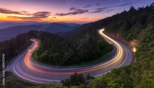 twilight traffic trails on winding forest road © Kristopher