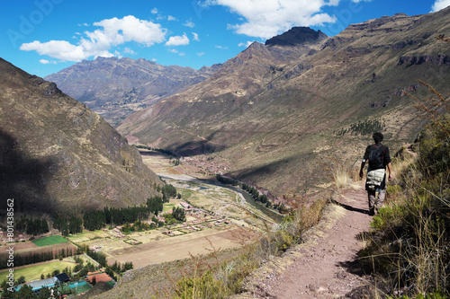 Young man hiker on the high trail of Pisac city overlooking the sacred valley and big mountains