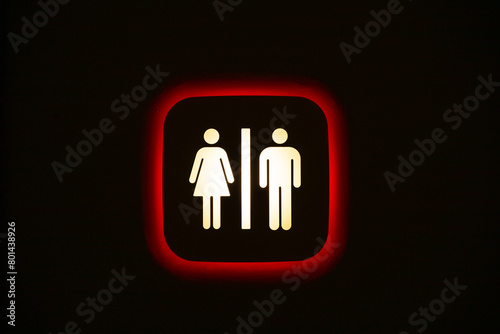 Unisex toilet sign on a black wall.