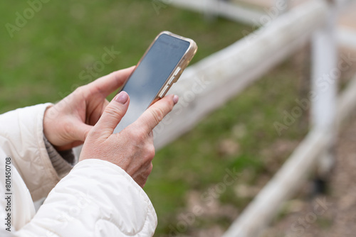 smartphone in the hand of a woman in the park. High quality photo