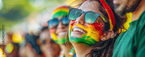Happy Bolivian female supporter with face painted in Bolivian flag colors, Bolivian fan at a sports event such as football, soccer or rugby match, blurry stadium background
 photo