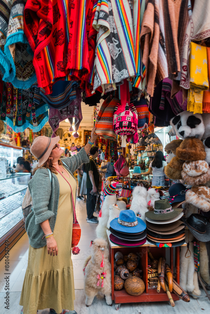 Naklejka premium Tourist looking at traditional Andean clothing. Concept of tourism