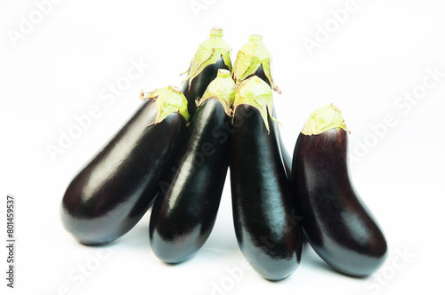 ripe dark eggplants on a white background. autumn eggplants on a light texture  © Григорий Юник