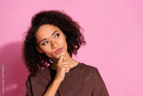 Photo of nice young girl look empty space ponder wear brown t-shirt isolated on pink color background
