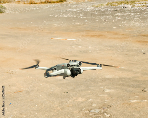View of a small gray drone in full flight