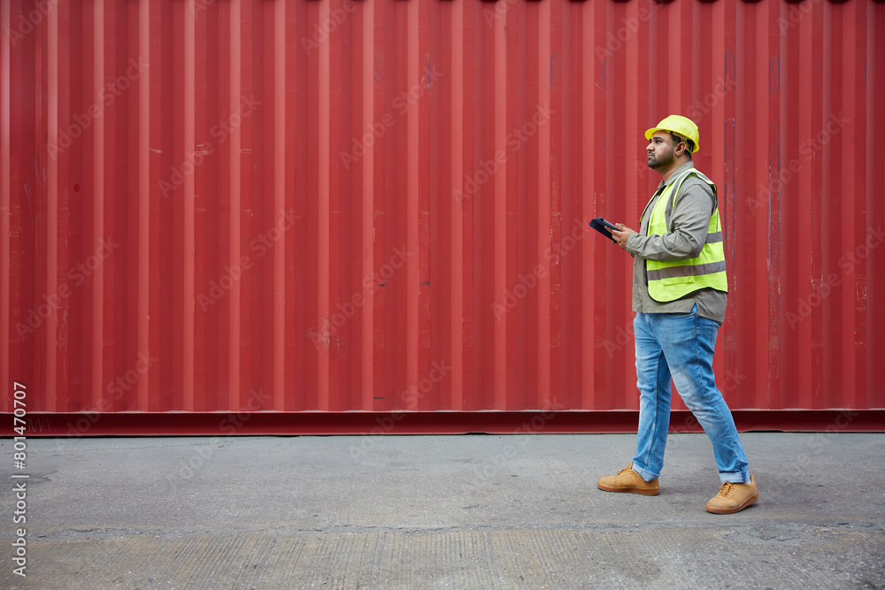 worker or engineer walking forward and working on tablet in containers warehouse storage worker or engineer walking forward and working on tablet in containers warehouse storage