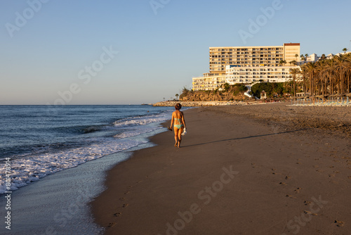 Woman during a morning walk along Bajondillo Beach in Torremolinos. Costa del Sol, Spain.