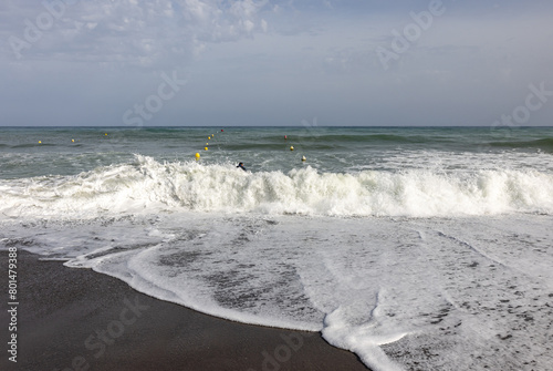  Foamy sea waves on the sandy beach of Bajondillo in Torremolinos, Malaga, Costa del Sol, Spain