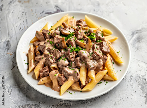 Penne pasta with mushrooms and cream sauce on a white plate.