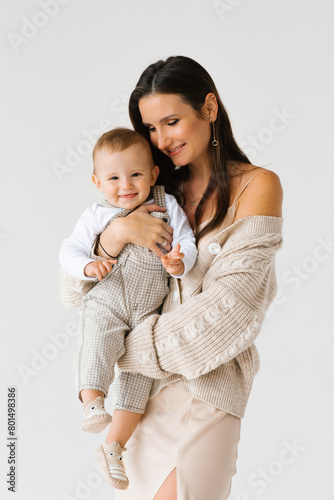 Happy young mother holding her little son in arms