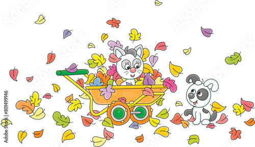 Happy little puppy and kitten playing with colorful autumn leaves and a handcart in a yard of a village house in countryside, vector cartoon illustration on a white background