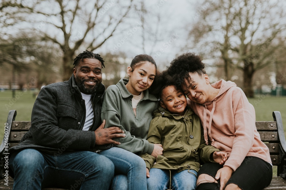 Happy African-American family sitting in a park Happy African-American family sitting in a park