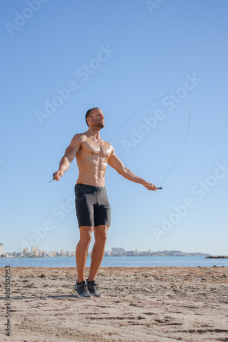 young man does exercises on the beach outdoors (ID: 801502953)