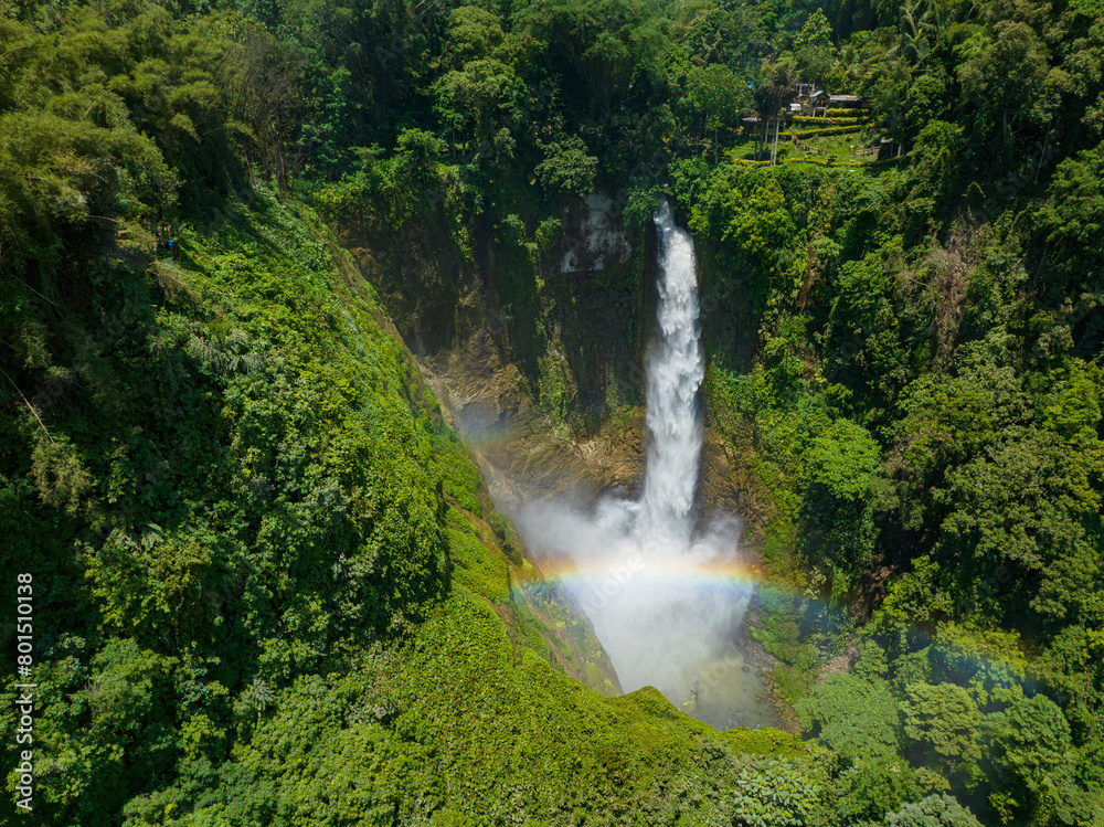 Hikong Bente with rainbow surrounded by lush green plants and trees. Lake Sebu. Mindanao, Philippines.
