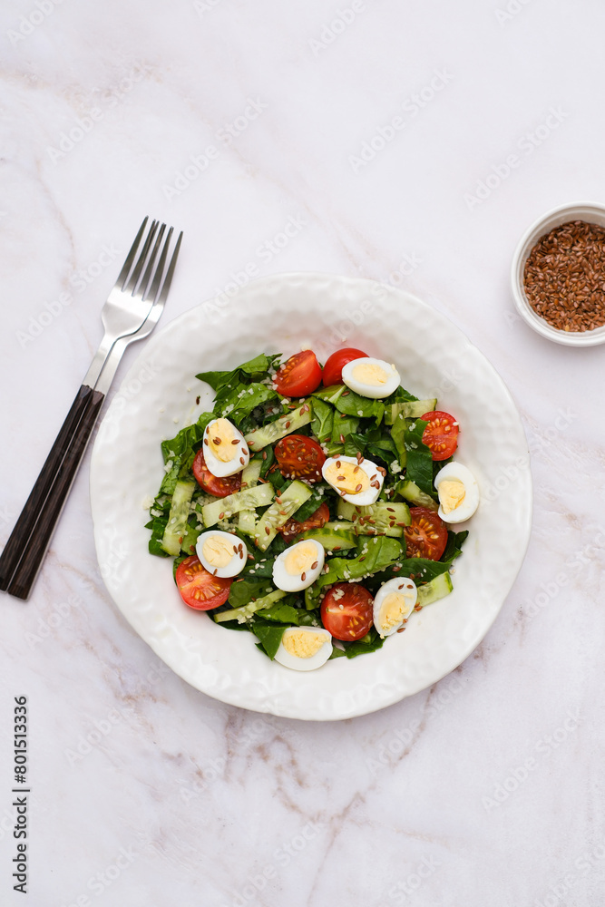 Fresh healthy vegetable salat: cucumber, tomatoes, spinach, couscous, quail eggs, flax seeds on marble background. Top view. Fresh healthy vegetable salat: cucumber, tomatoes, spinach, couscous, quail eggs, flax seeds on marble background. Top view.