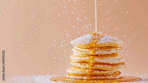 A tempting stack of fluffy pancakes, generously drizzled with flowing maple syrup and dusted with powdered sugar