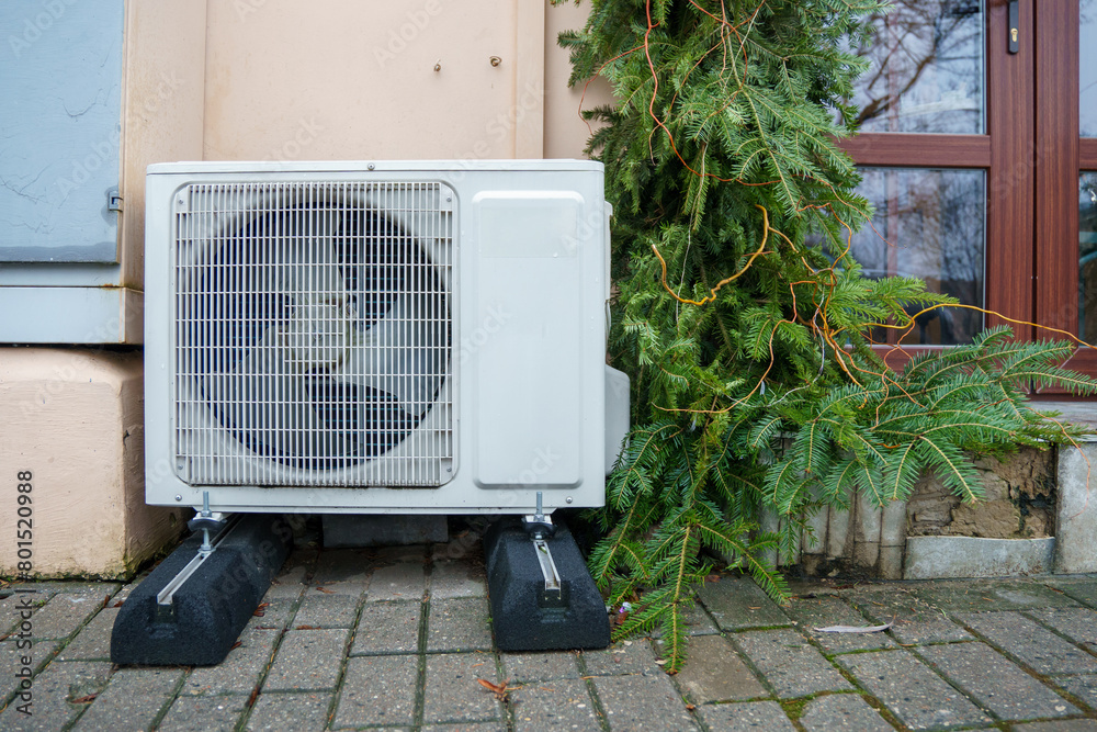 Outdoor air conditioning unit. A large modern air conditioner on the wall of an apartment building. Repair and maintenance of the air conditioning system Outdoor air conditioning unit. A large modern air conditioner on the wall of an apartment building. Repair and maintenance of the air conditioning system