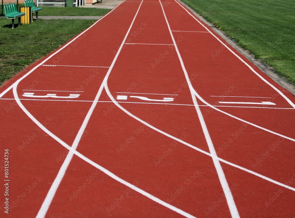 the starting point of the red running track of the athletics stadium with three numbered lanes
