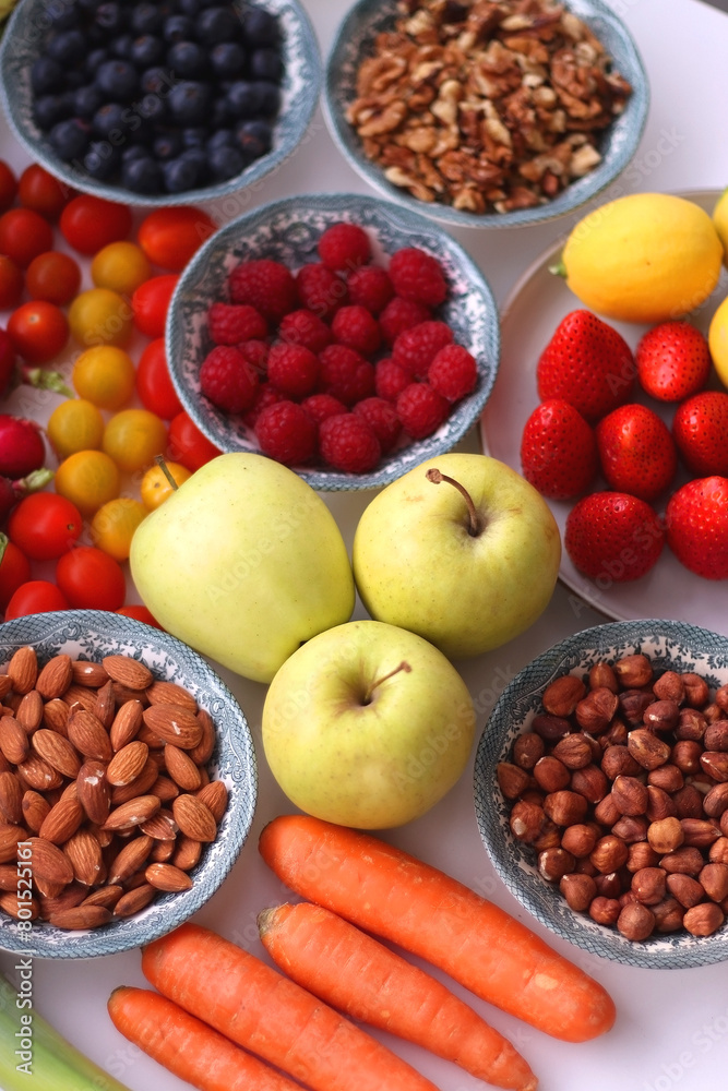 Apples, lemons, bananas, berries, carrots, leek, tomatoes, radishes, spinach and various nuts on white background. Healthy seasonal fruit and vegetable. Selective focus. Apples, lemons, bananas, berries, carrots, leek, tomatoes, radishes, spinach and various nuts on white background. Healthy seasonal fruit and vegetable. Selective focus.