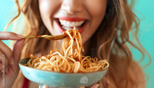 Young woman eating tasty pasta on green background  closeup