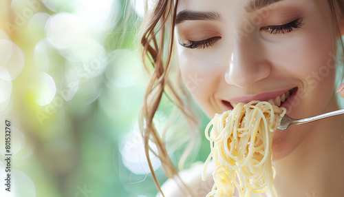 Young woman eating tasty pasta on green background  closeup