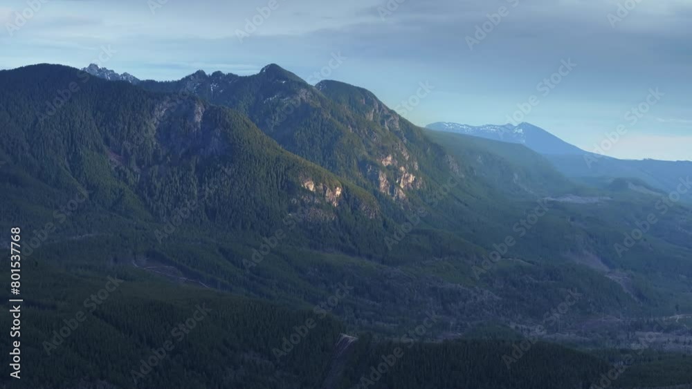An aerial view reveals the vast expanse of lush greenery cloaking the rolling mountains of Washington, bathed in soft daylight. 4K footage. An aerial view reveals the vast expanse of lush greenery cloaking the rolling mountains of Washington, bathed in soft daylight. 4K footage.