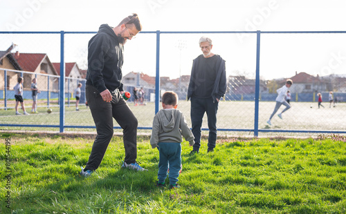 Family moment with toddler playing football