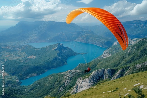 Man is flying a paraglider over a mountainous landscape